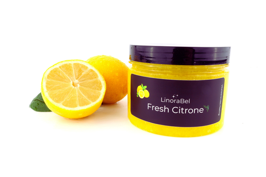 Zitronen Body Peeling aus 100% Bio Zutaten, vegan, leuchtend gelb im Tiegel mit frischer Zitrone auf hellem Hintergrund.